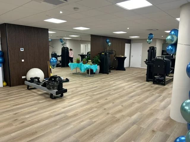 Fitnesszaal met krachtoefentoestellen en spiegel